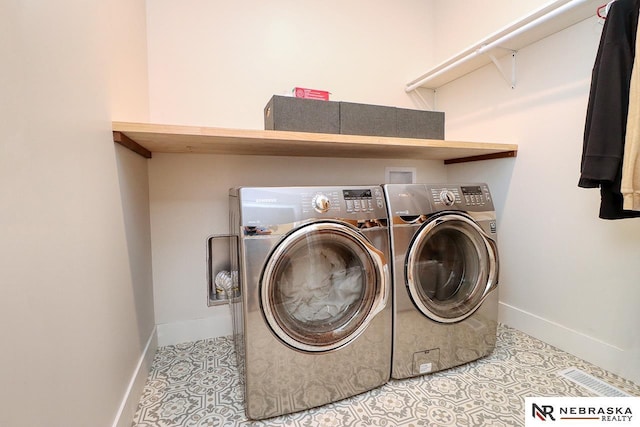 laundry area with washing machine and dryer and tile patterned floors