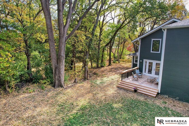 view of yard featuring a wooden deck and french doors