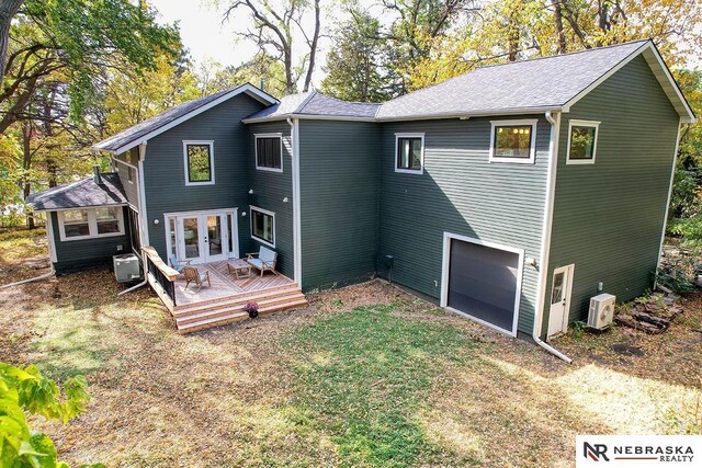 back of house with a garage, central AC, a deck, and french doors