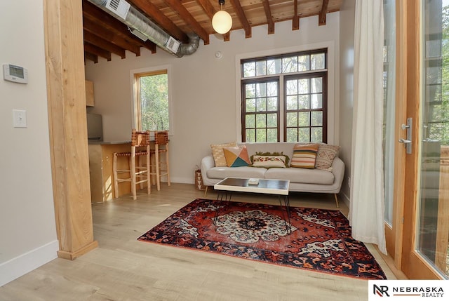 living area with wood ceiling, beamed ceiling, and plenty of natural light