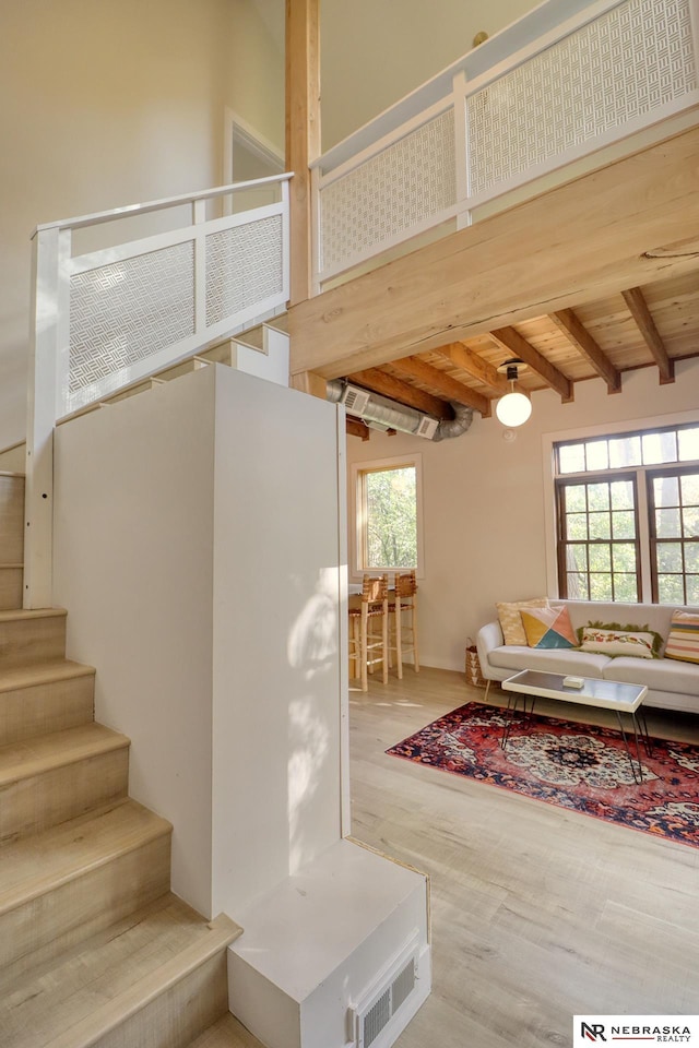 living room with high vaulted ceiling, wooden ceiling, wood-type flooring, and beamed ceiling