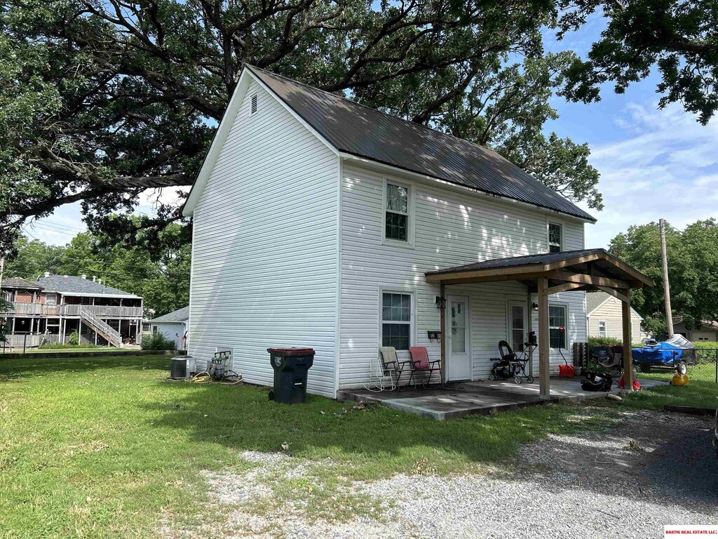 back of property with cooling unit, a patio, and a lawn