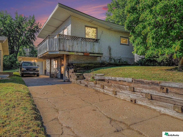 view of front facade featuring a balcony and a lawn