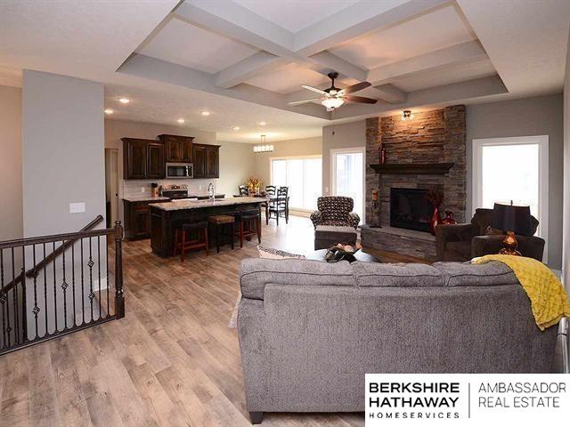 living room with beamed ceiling, a fireplace, light wood-type flooring, ceiling fan, and coffered ceiling