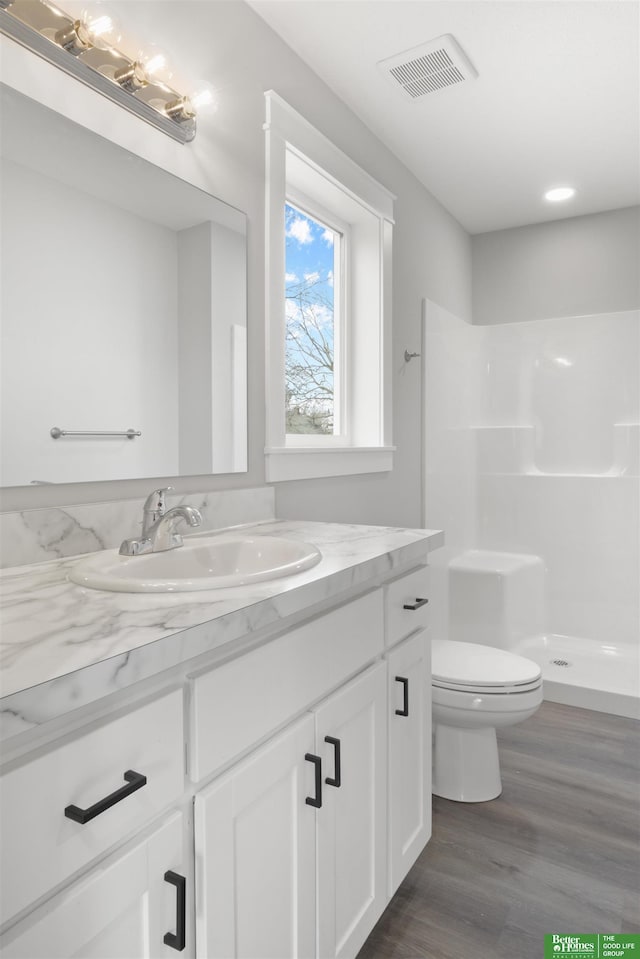 bathroom with vanity, toilet, a shower, and hardwood / wood-style flooring