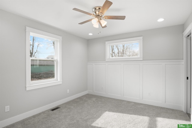 empty room featuring ceiling fan and light carpet