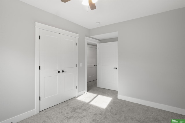 unfurnished bedroom with light colored carpet, a closet, and ceiling fan