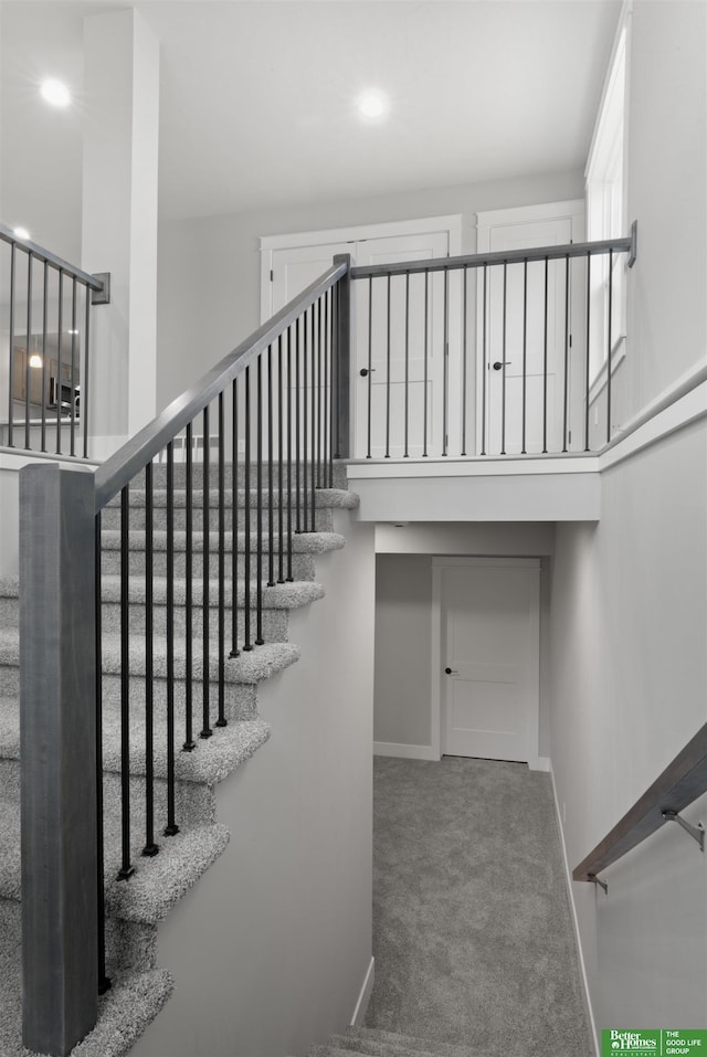 stairway featuring carpet flooring