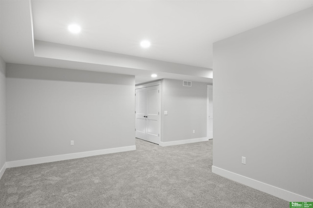 basement featuring light carpet