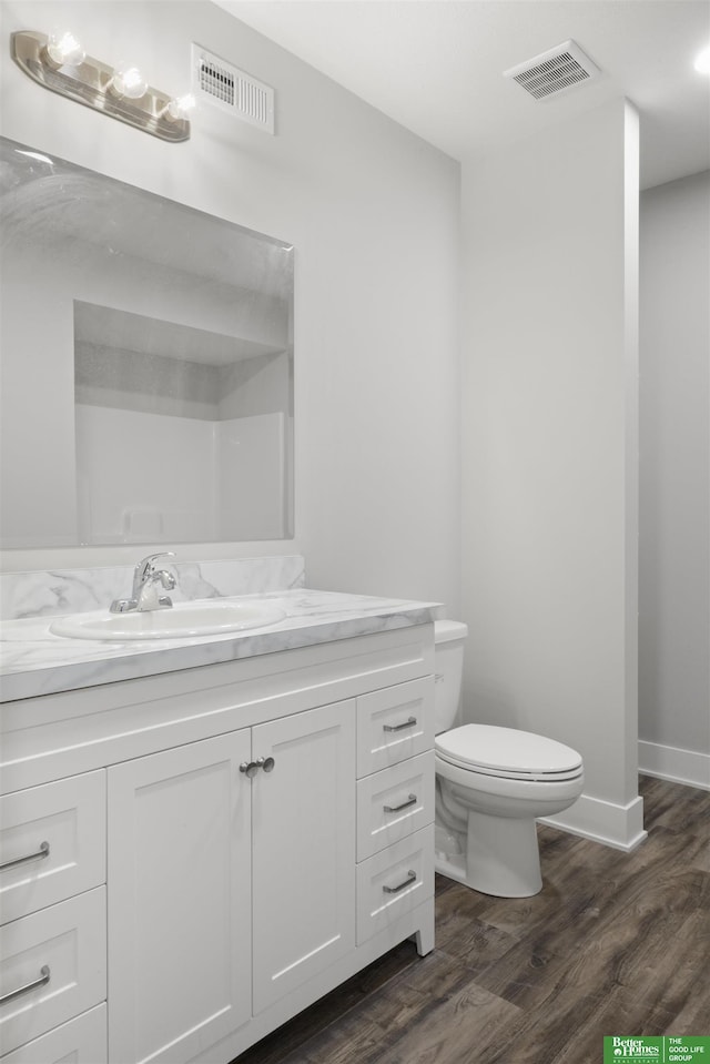 bathroom featuring vanity, hardwood / wood-style flooring, and toilet