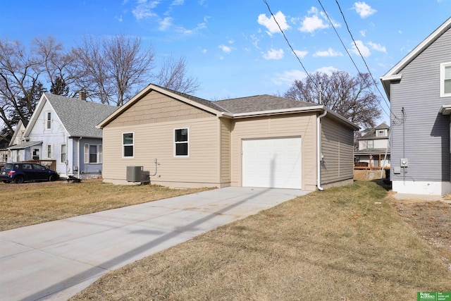 view of side of home with a garage, a yard, and central AC