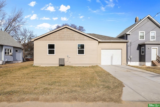 exterior space with a garage, central air condition unit, and a front yard