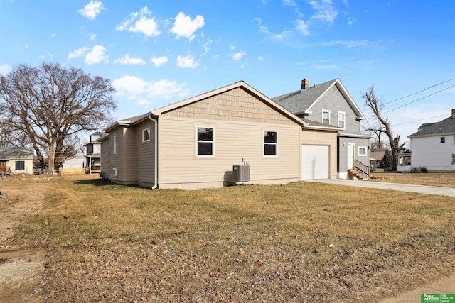 back of property featuring a lawn, central AC, and a garage