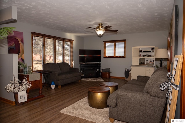 living room featuring ceiling fan, hardwood / wood-style flooring, and a textured ceiling