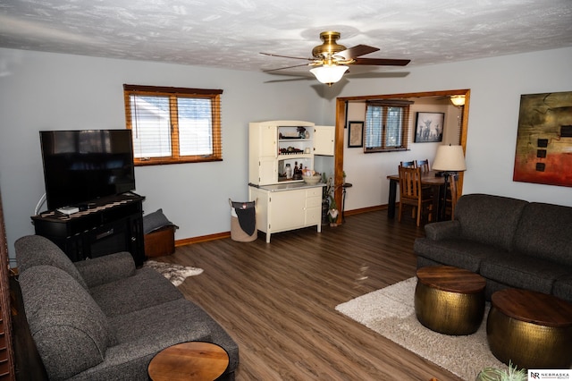 living room with ceiling fan, dark hardwood / wood-style floors, and a textured ceiling