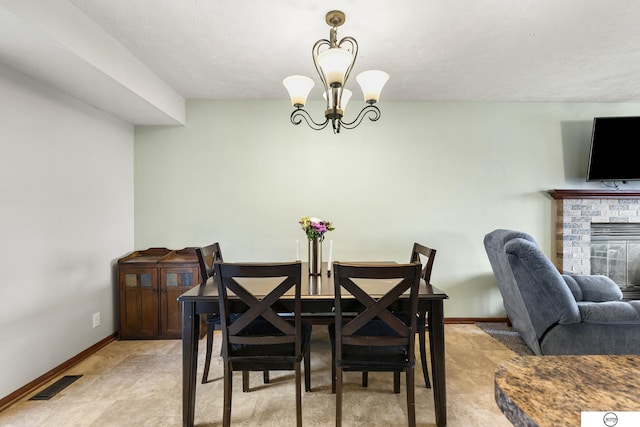 dining space with an inviting chandelier and a brick fireplace