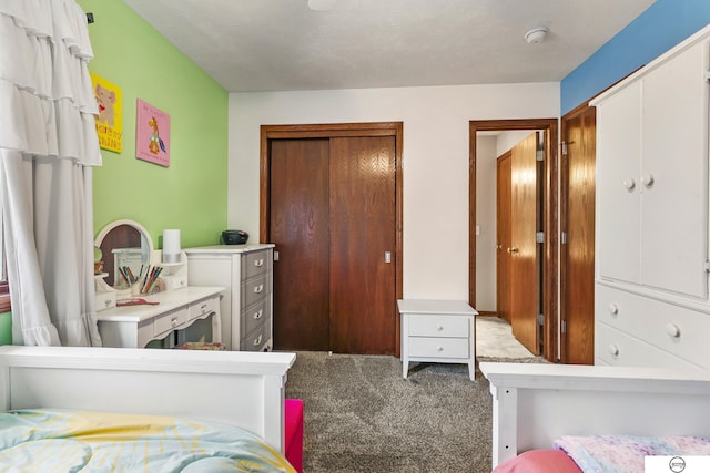 bedroom with a closet, carpet, and a textured ceiling