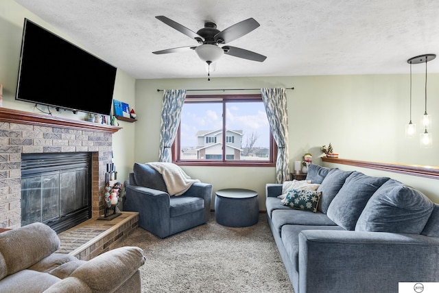 carpeted living room featuring a brick fireplace, a textured ceiling, and ceiling fan