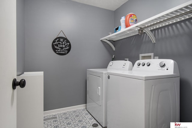 laundry room with washing machine and clothes dryer and a textured ceiling