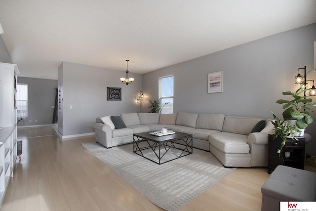 living room featuring a notable chandelier and light hardwood / wood-style floors