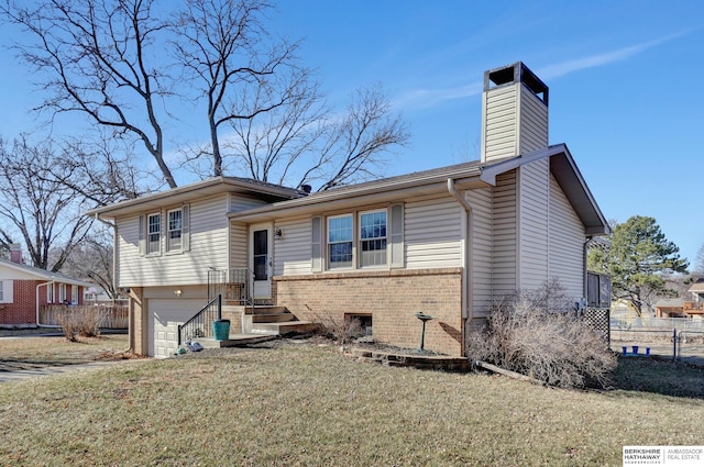 split level home with a garage and a front lawn