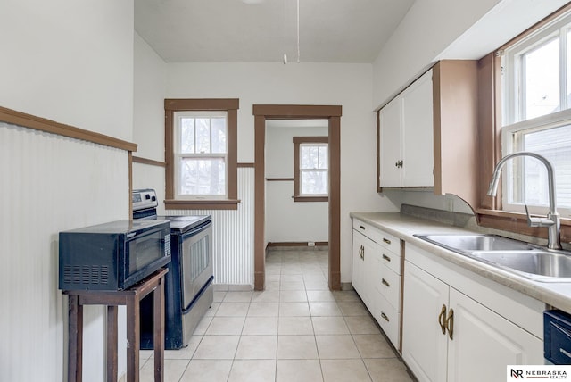 kitchen featuring sink, white cabinets, plenty of natural light, and stainless steel range with electric stovetop