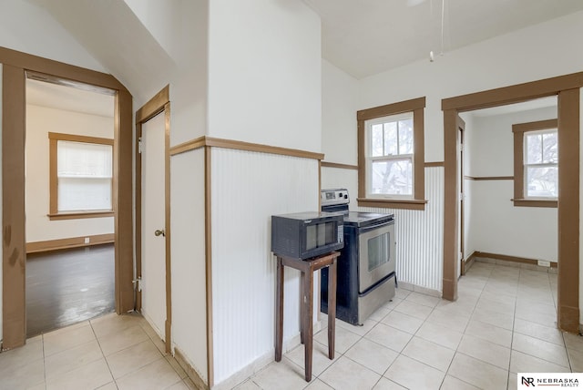 kitchen featuring light tile patterned flooring and stainless steel range with electric stovetop