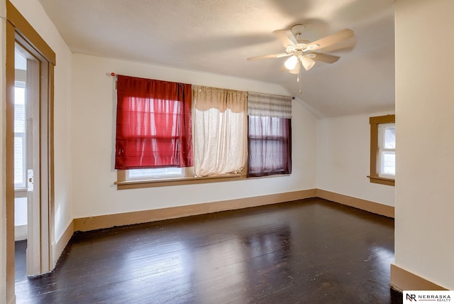 unfurnished room with ceiling fan, lofted ceiling, and dark hardwood / wood-style flooring