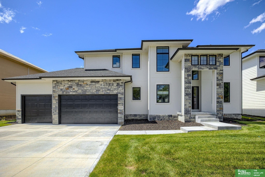 view of front of home with a garage and a front lawn