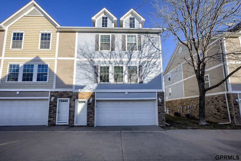 multi unit property featuring a garage and central air condition unit