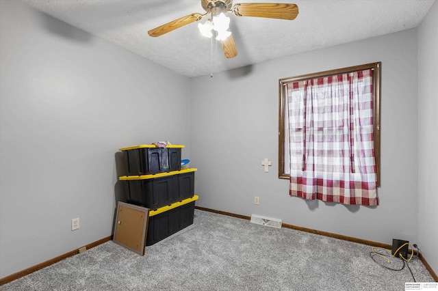 interior space with a textured ceiling, ceiling fan, and carpet flooring