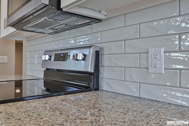 details featuring white cabinets, light stone countertops, decorative backsplash, and stainless steel electric range