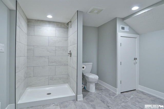 bathroom with toilet and tiled shower