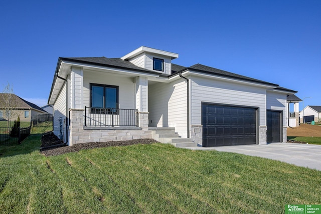 view of front of house with a porch, a garage, and a front lawn