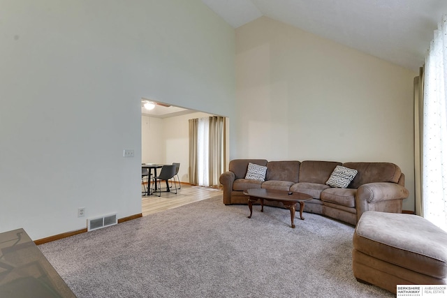 living room featuring vaulted ceiling and light colored carpet