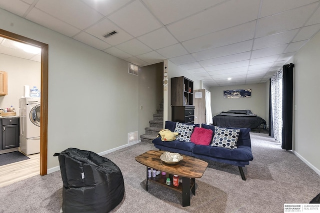 carpeted living room featuring washer / clothes dryer and a paneled ceiling