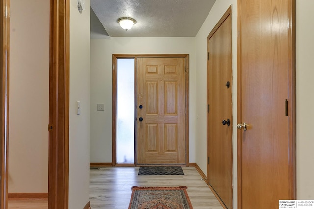 foyer featuring a textured ceiling and light wood-type flooring