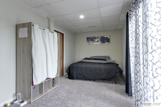 bedroom with light carpet and a paneled ceiling