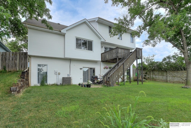 back of property featuring a wooden deck, a yard, and central AC