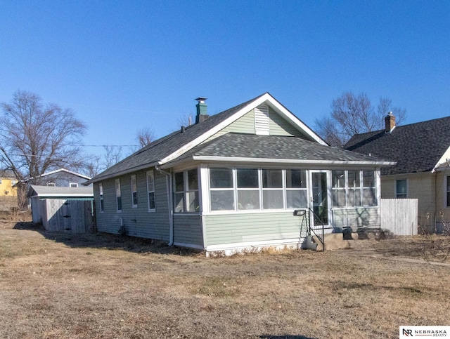 view of front of property featuring a sunroom and a front yard