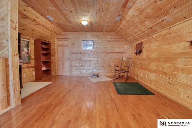 interior space with wood ceiling, wooden walls, and vaulted ceiling