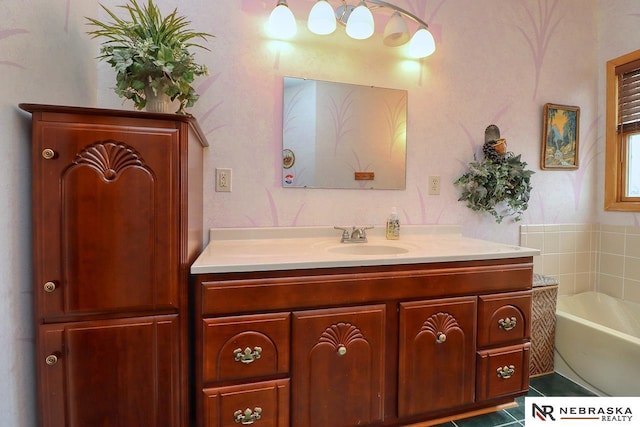 bathroom with tile patterned floors, a tub to relax in, and vanity