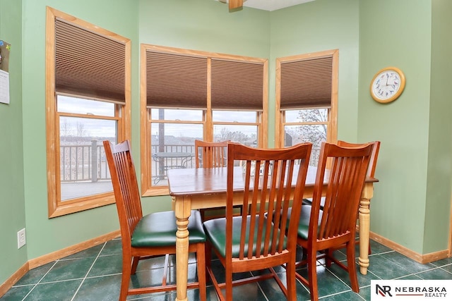 dining room featuring plenty of natural light and dark tile patterned flooring