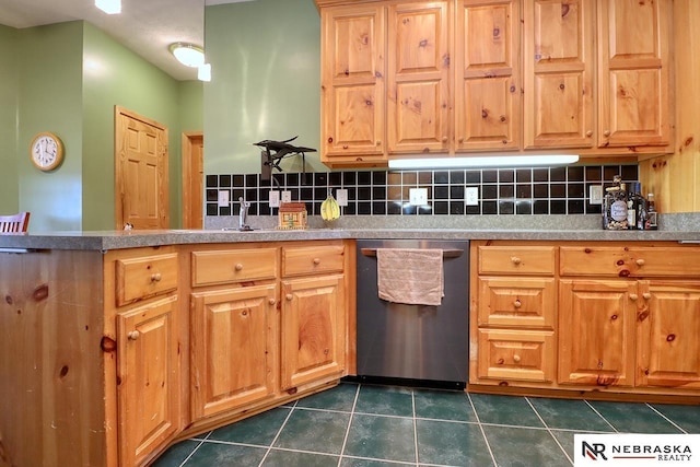 kitchen with stainless steel dishwasher, dark tile patterned flooring, sink, and backsplash