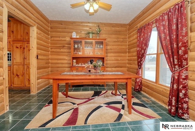 home office featuring ceiling fan and rustic walls