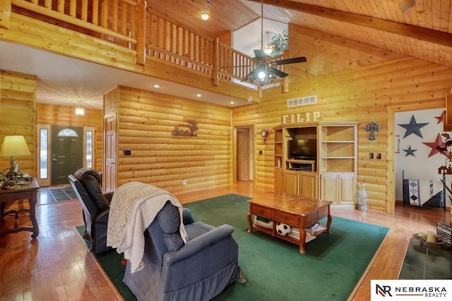 living room featuring rustic walls, high vaulted ceiling, wooden ceiling, beam ceiling, and hardwood / wood-style floors