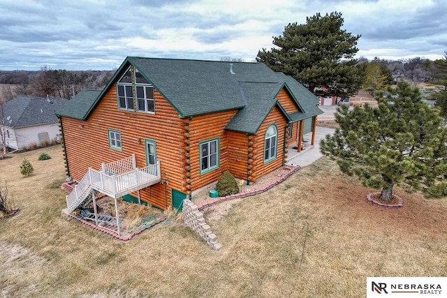 rear view of house featuring a wooden deck and a lawn