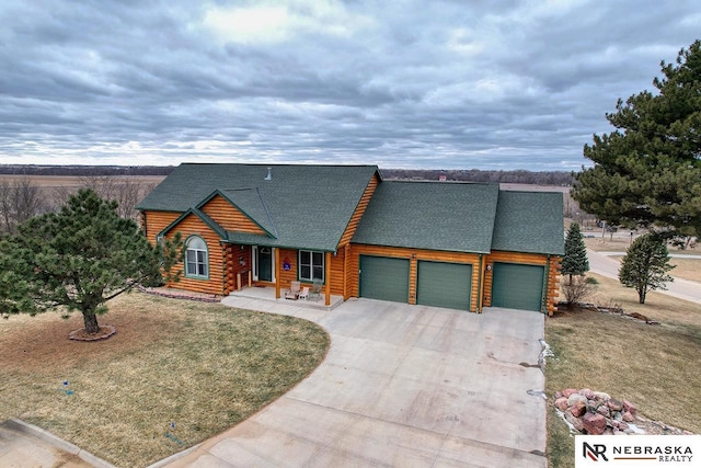 log-style house featuring a garage and a front lawn