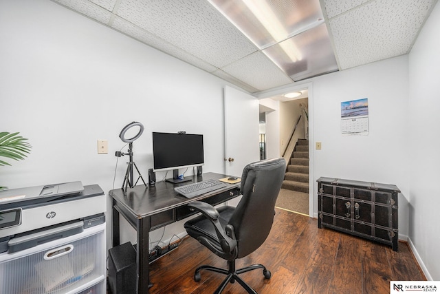 office space with a paneled ceiling, baseboards, and wood finished floors