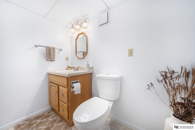 half bath featuring baseboards, toilet, and vanity